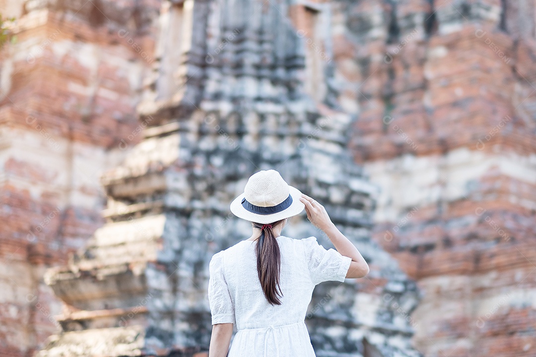 Mulher turista de vestido branco visitando a antiga stupa em Wat Ch