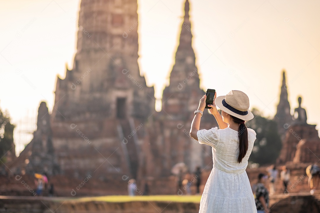 Mulher turista feliz em vestido branco tirando foto pelo smartphone móvel