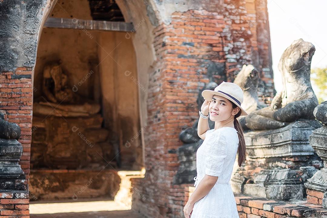 Mulher turista de vestido branco visitando a antiga stupa