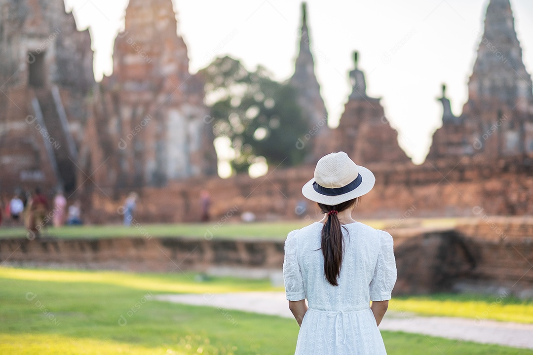 Mulher turista de vestido branco visitando a antiga stupa em Wat Ch