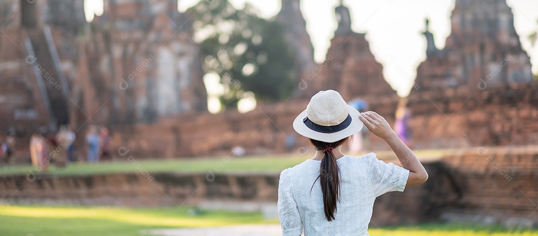Mulher turista de vestido branco visitando a antiga stupa em Wat Ch