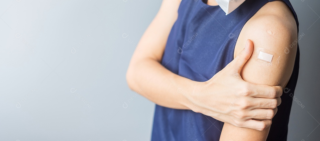 mulher mostrando o braço com curativo após receber covid 19