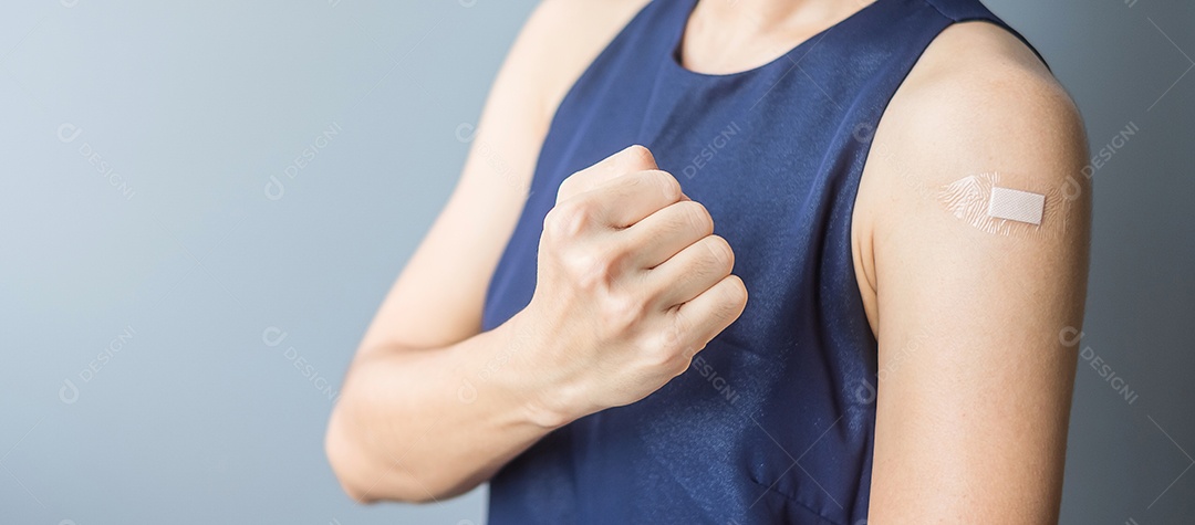 Mulher feliz mostrando sinal de vitória com curativo depois de receber covid 19