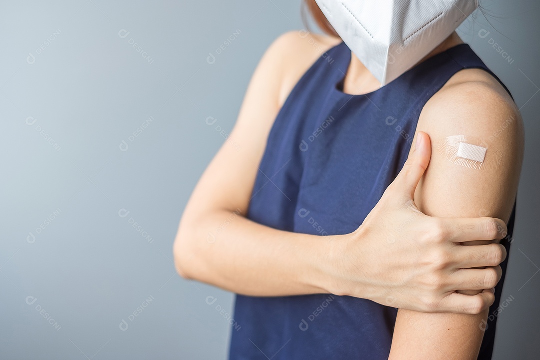 Mulher feliz mostrando sinal de vitória com curativo depois de receber covid 19