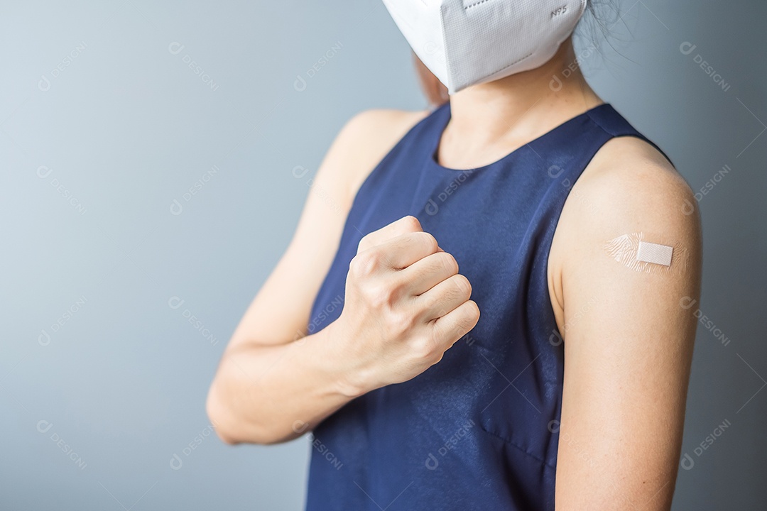 Mulher feliz mostrando sinal de punho com curativo depois de receber covid