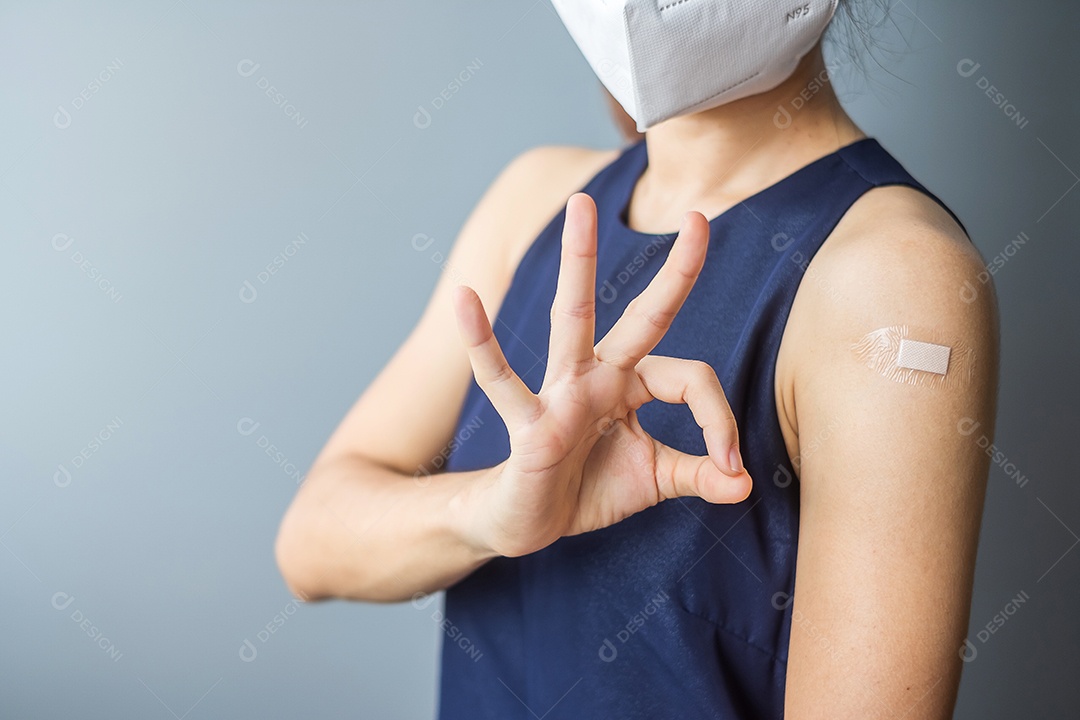 mulher mostrando o braço com curativo após receber covid 19