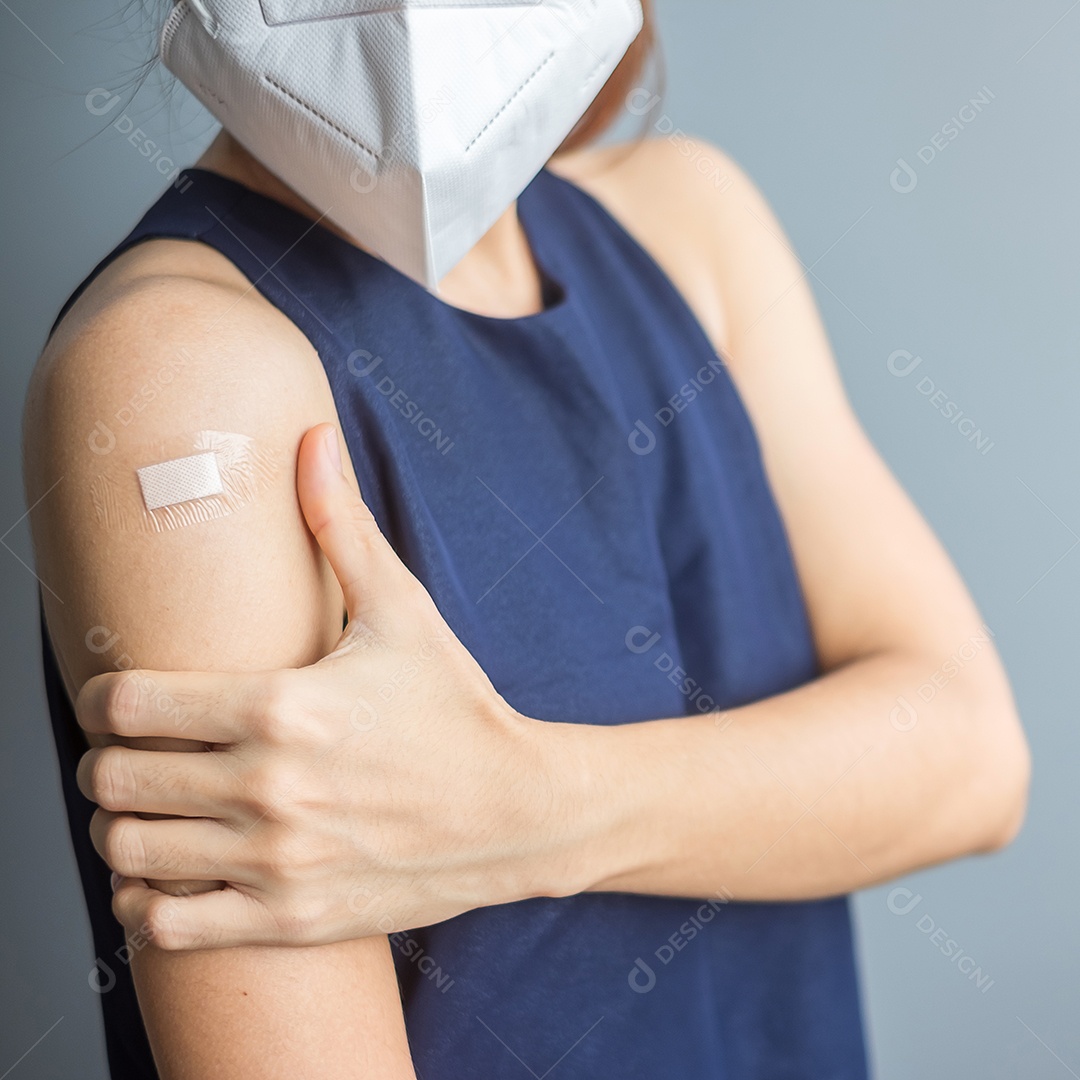 mulher mostrando o braço com curativo após receber covid 19