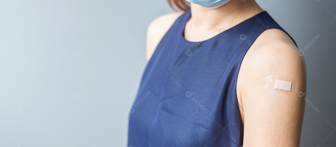 Mulher feliz mostrando o braço com curativo depois de receber covid