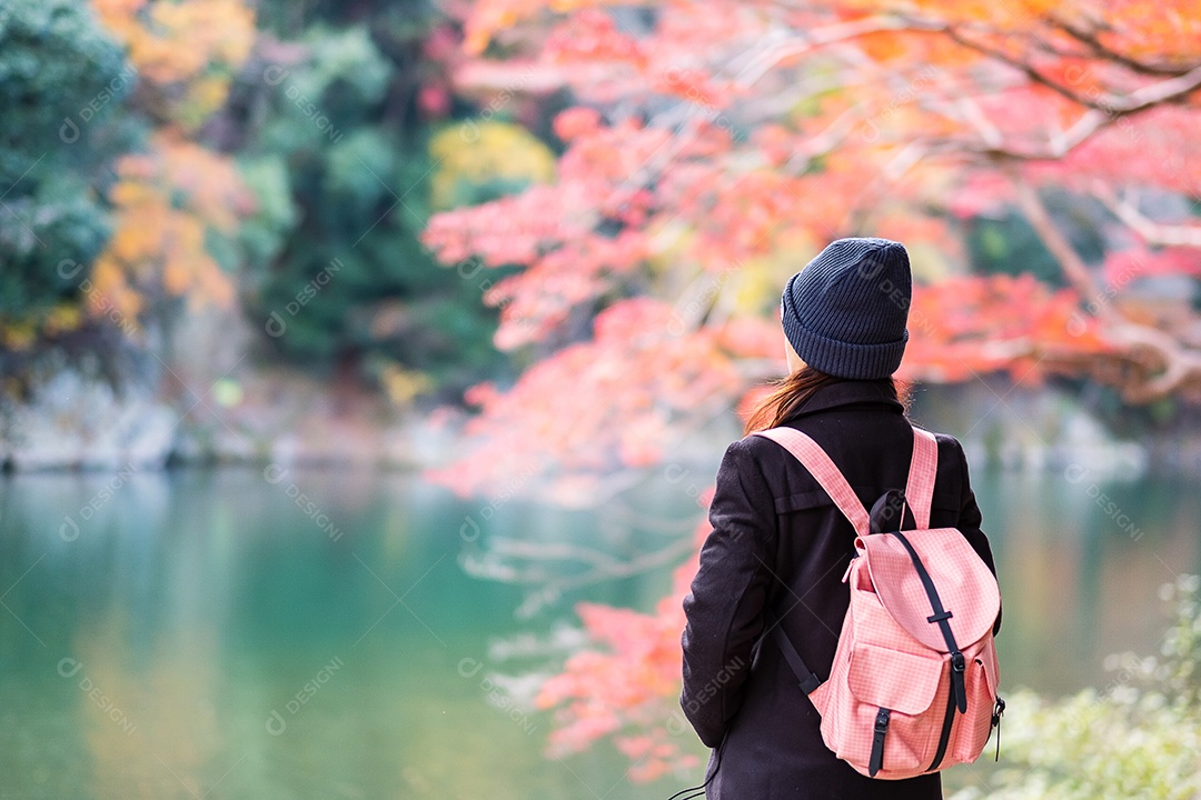 Mulher feliz turista olhando folhas coloridas e rio Katsura