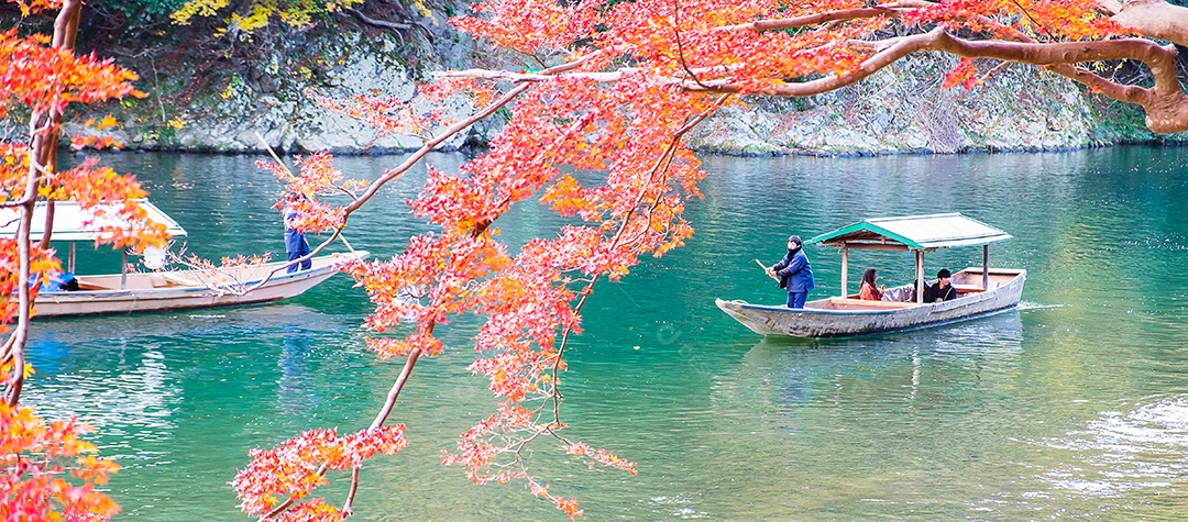 Turistas passeando em belas folhas coloridas Rio Hozugawa