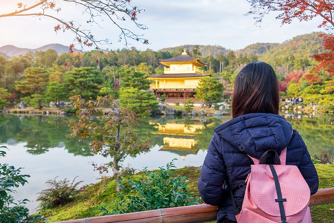 Turista solo viajando no templo Kinkakuji ou no pavilhão dourado na temporada de outono, visita de viajante asiático em Kyoto, Japão. Conceito de férias, destino e viagens