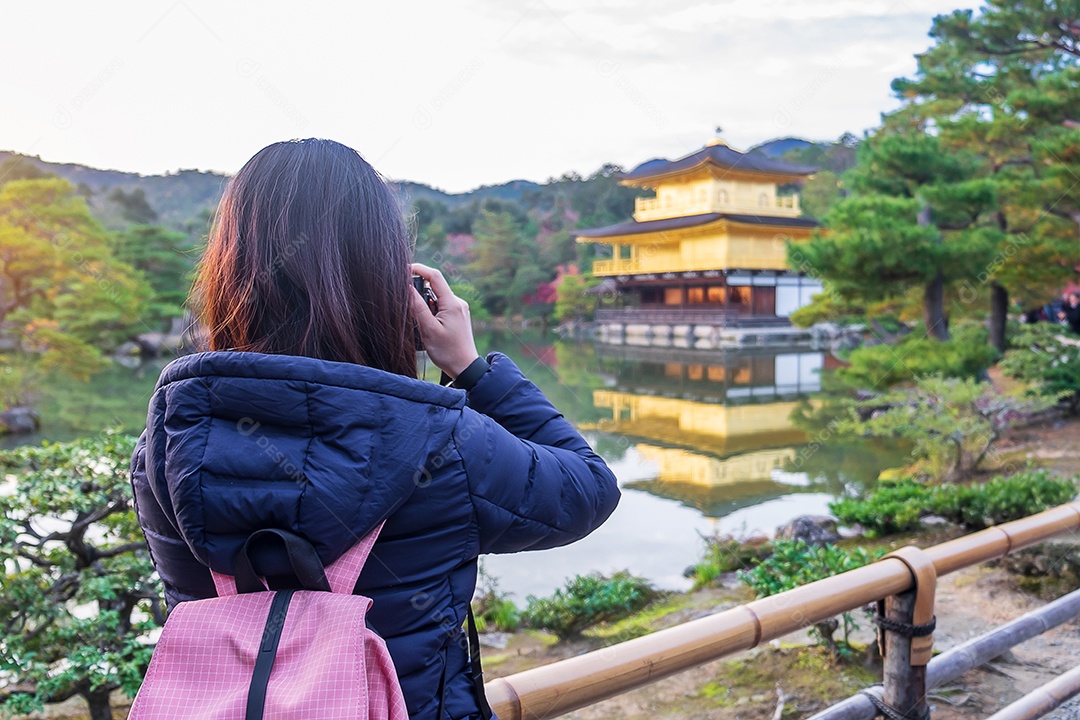 Turista solo tirando foto pela câmera no templo Kinkakuji ou no pavilhão dourado na temporada de outono, visita de viajante asiático em Kyoto, Japão. Conceito de férias, destino e viagens