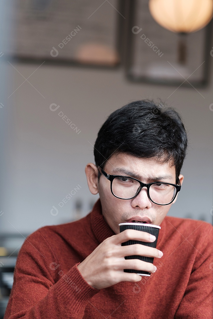 Homem de suéter bebendo café quente no restaurante