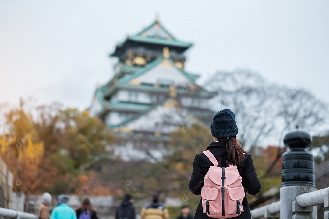 Turista solo viajando no castelo de Osaka na temporada de outono, visita de viajante asiático na cidade de Osaka, Japão. Conceito de férias, destino e viagens