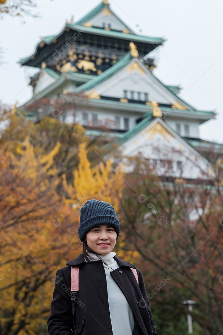 Mulher feliz desfruta no parque ao ar livre na temporada de outono, viajante asiático de casaco e chapéu contra o fundo Yellow Ginkgo Leaves