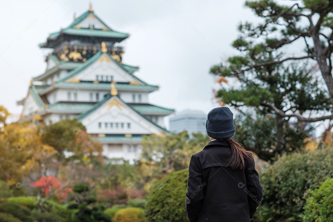 Turista solo viajando no castelo de Osaka na temporada de outono, visita de viajante asiático na cidade de Osaka, Japão. Conceito de férias, destino e viagens
