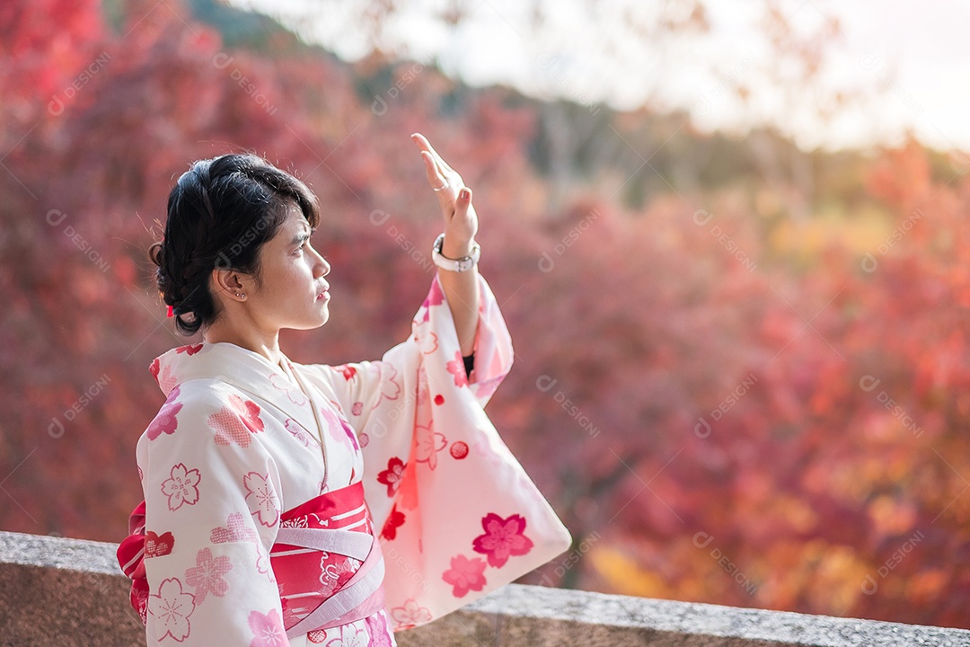 Turista jovem vestindo quimono desfrutando com folhas coloridas no templo Kiyomizu dera, Kyoto, Japão. Menina asiática com estilo de cabelo em roupas tradicionais japonesas na temporada de folhagem de outono