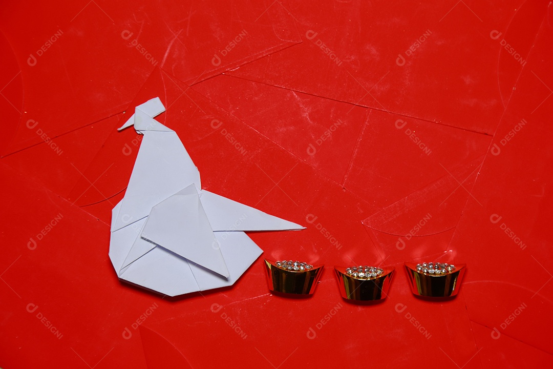 Ofício de origami artesanal de galo dobrado de papel em fundo de pacotes vermelhos. 2017 é o ano do Galo.