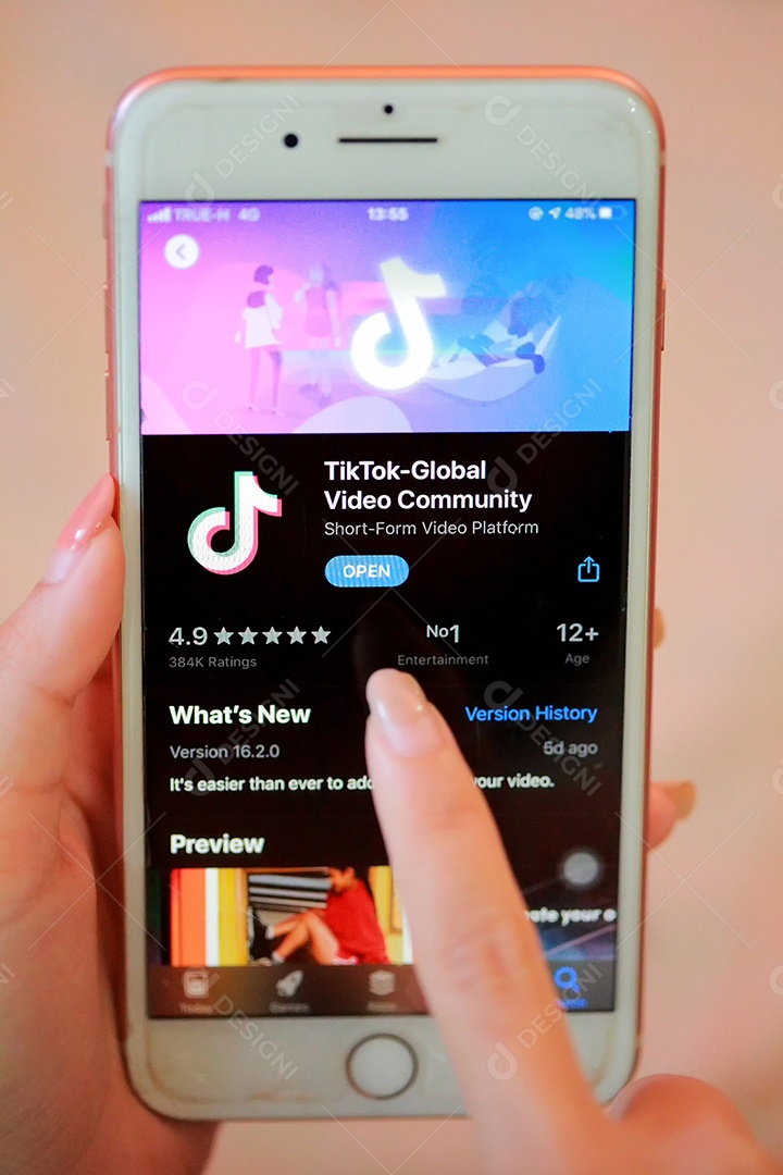 Aplicativo Tik Tok no iPhone 8, dedo prestes a tocá-lo.que é uma rede de mídia social popular é um aplicativo