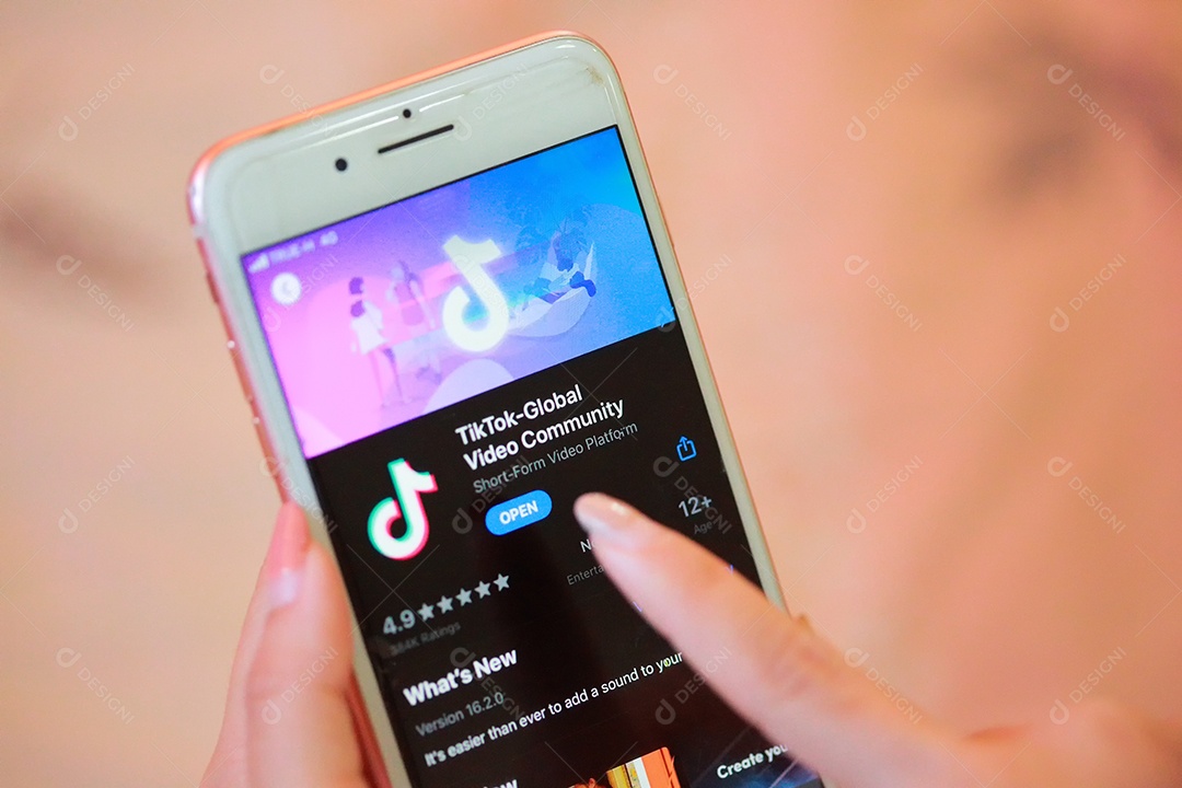 Aplicativo Tik Tok no iPhone 8, dedo prestes a tocá-lo.que é uma rede de mídia social popular é um aplicativo