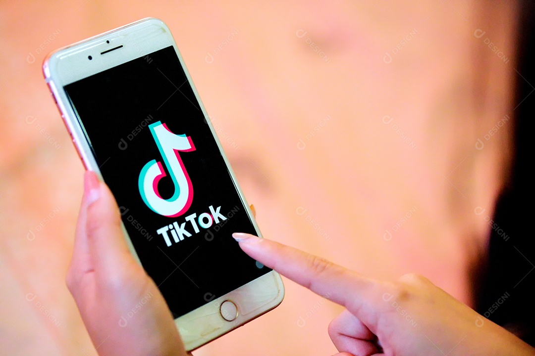 Aplicativo Tik Tok no iPhone 8, dedo prestes a tocá-lo.que é uma rede de mídia social popular é um aplicativo