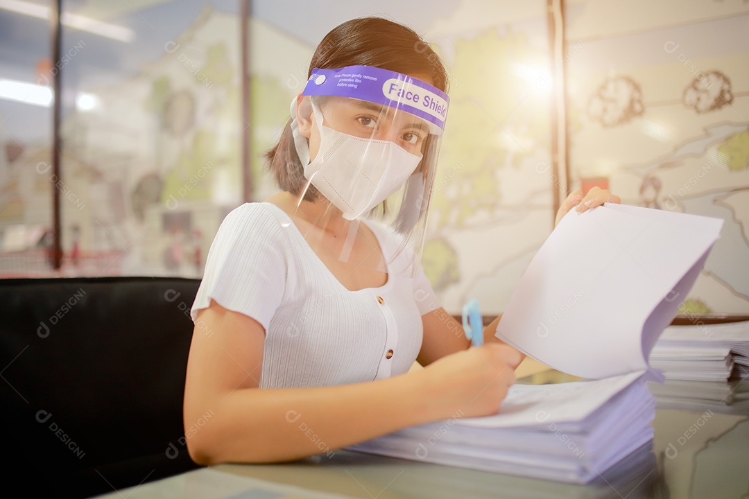 Mulher trabalhadora de escritório usando protetor facial. em quarentena para coronavírus
