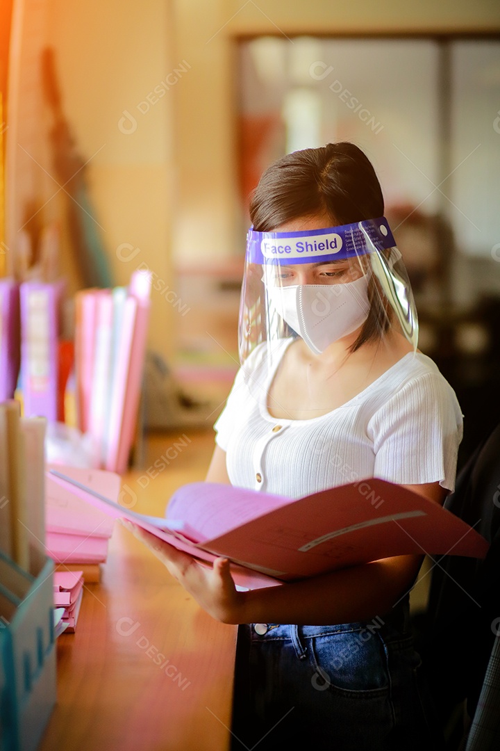 Mulher trabalhadora de escritório usando protetor facial. em quarentena para coronavírus