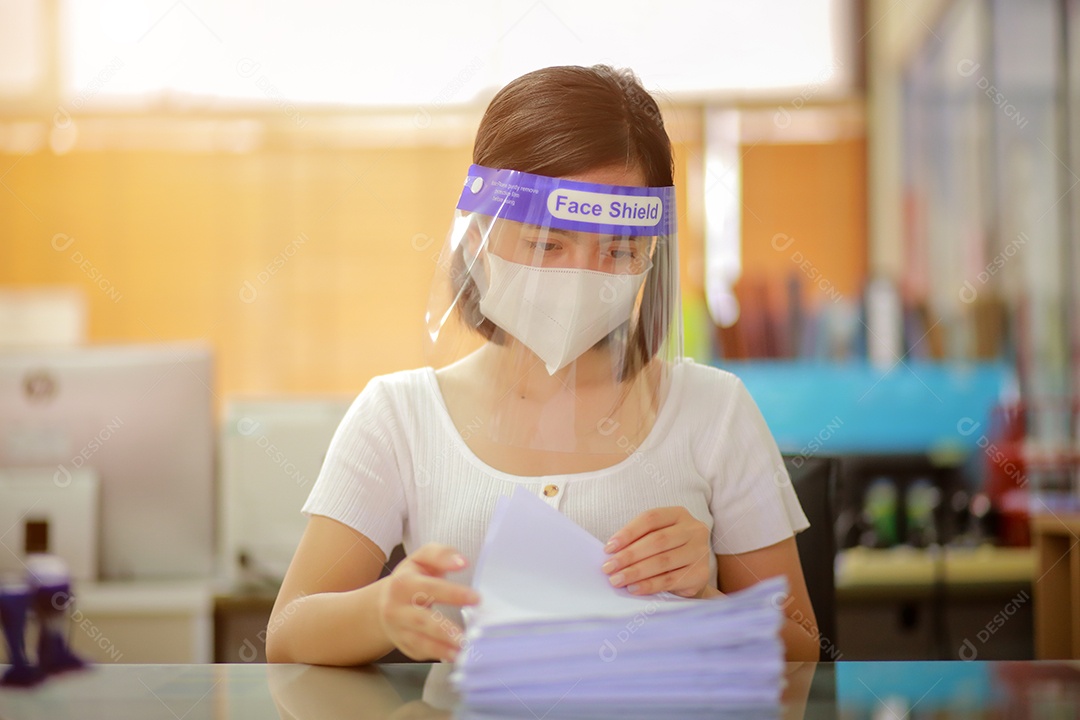 Mulher trabalhadora de escritório usando protetor facial. em quarentena para coronavírus