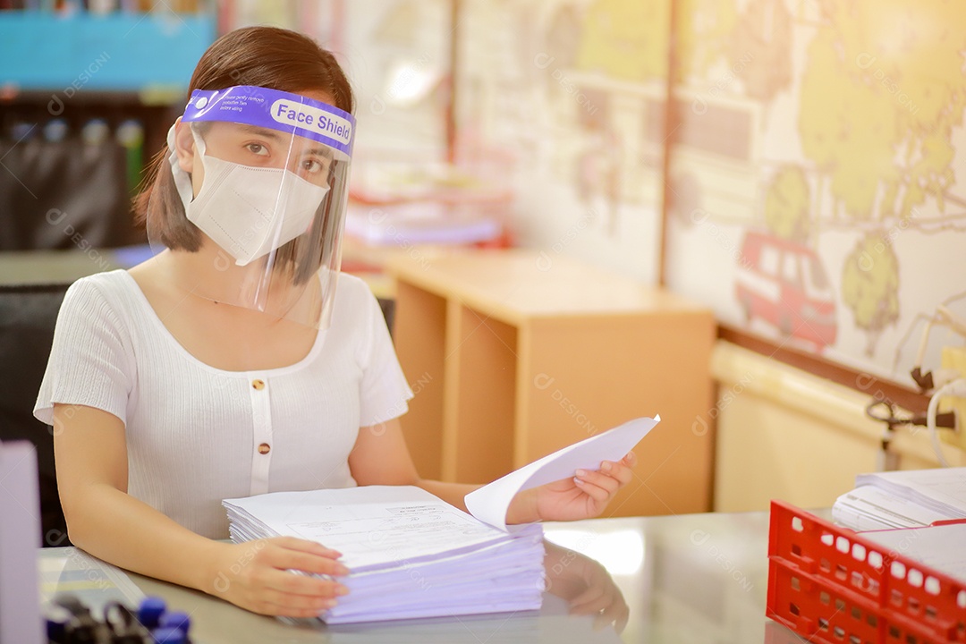 Mulher trabalhadora de escritório usando protetor facial. em quarentena para coronavírus