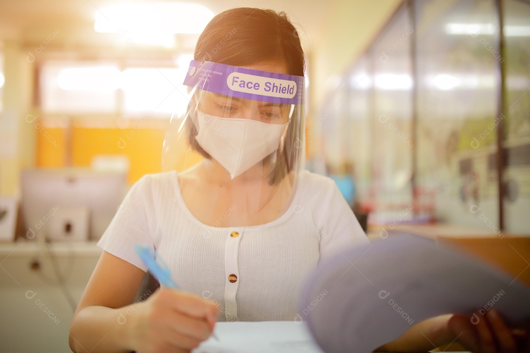 Mulher trabalhadora de escritório usando protetor facial. em quarentena para coronavírus