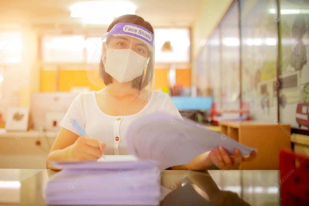 Mulher trabalhadora de escritório usando protetor facial. em quarentena para coronavírus