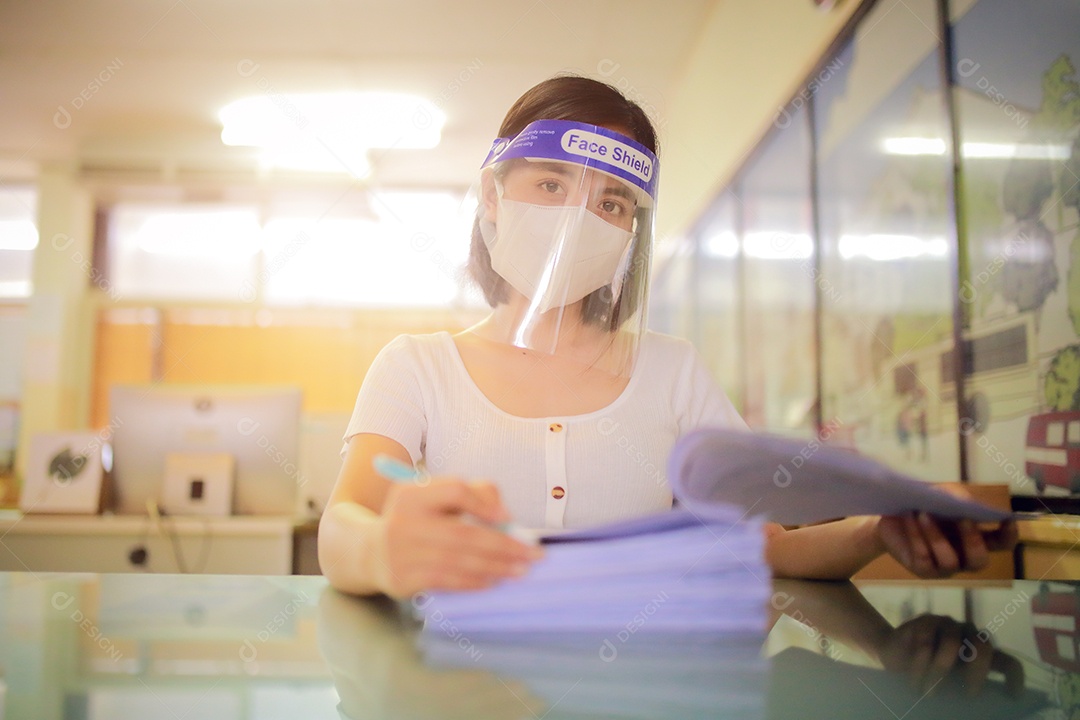 Mulher trabalhadora de escritório usando protetor facial. em quarentena para coronavírus