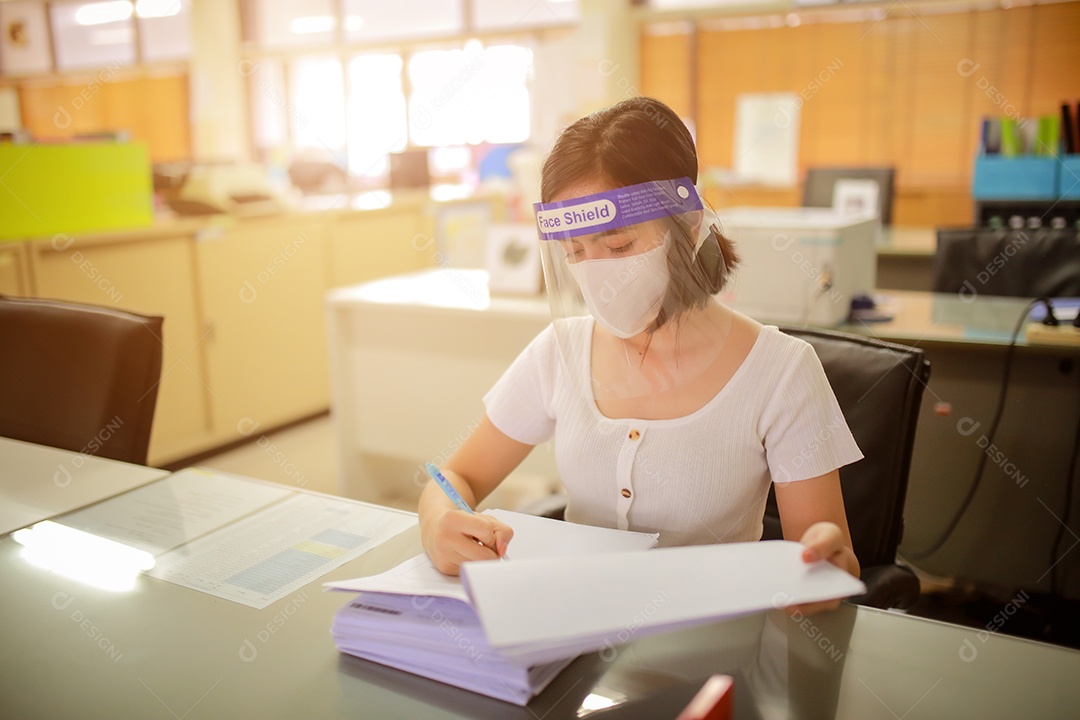 Mulher trabalhadora de escritório usando protetor facial. em quarentena para coronavírus