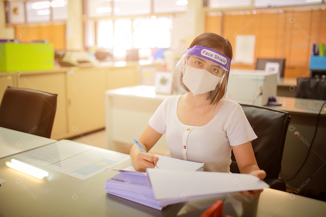 Mulher trabalhadora de escritório usando protetor facial. em quarentena para coronavírus