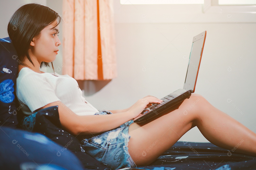 Jovem relaxando e usando o laptop no trabalho