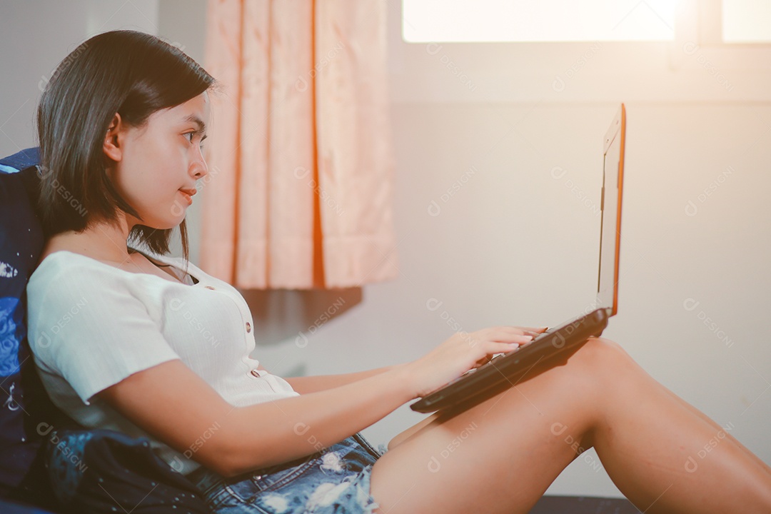 Jovem relaxando e usando o laptop no trabalho