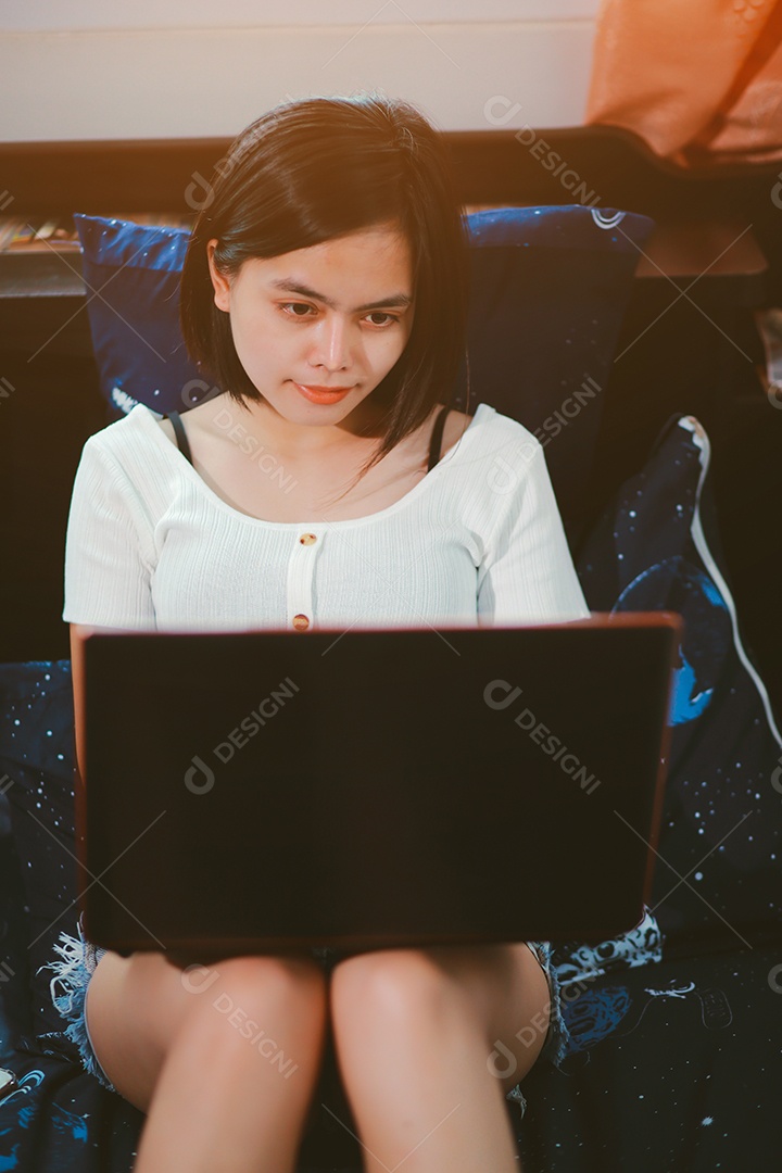 Jovem relaxando e usando o laptop no trabalho