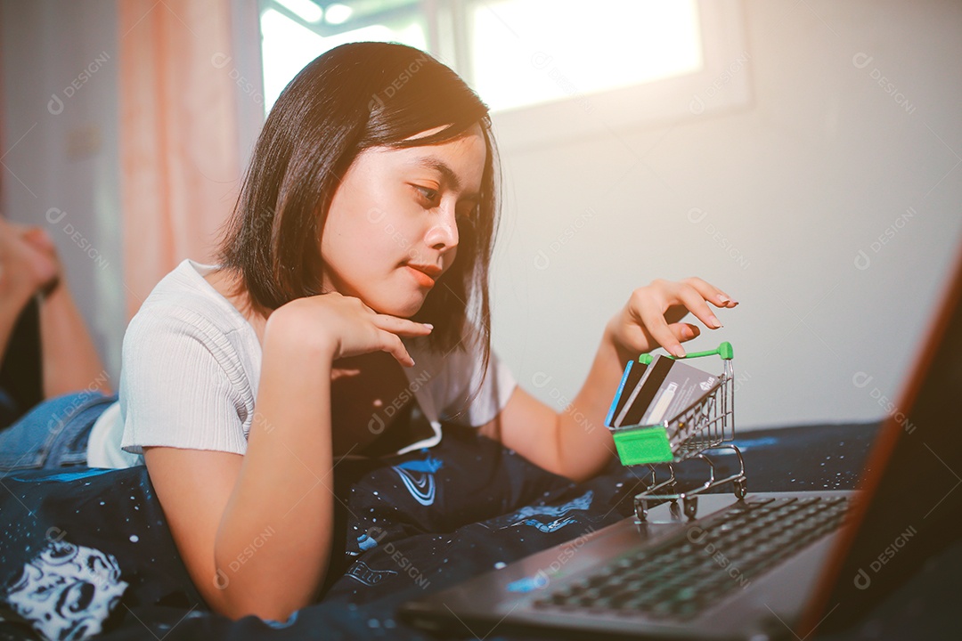 Jovem relaxando e usando o laptop fazendo compras online