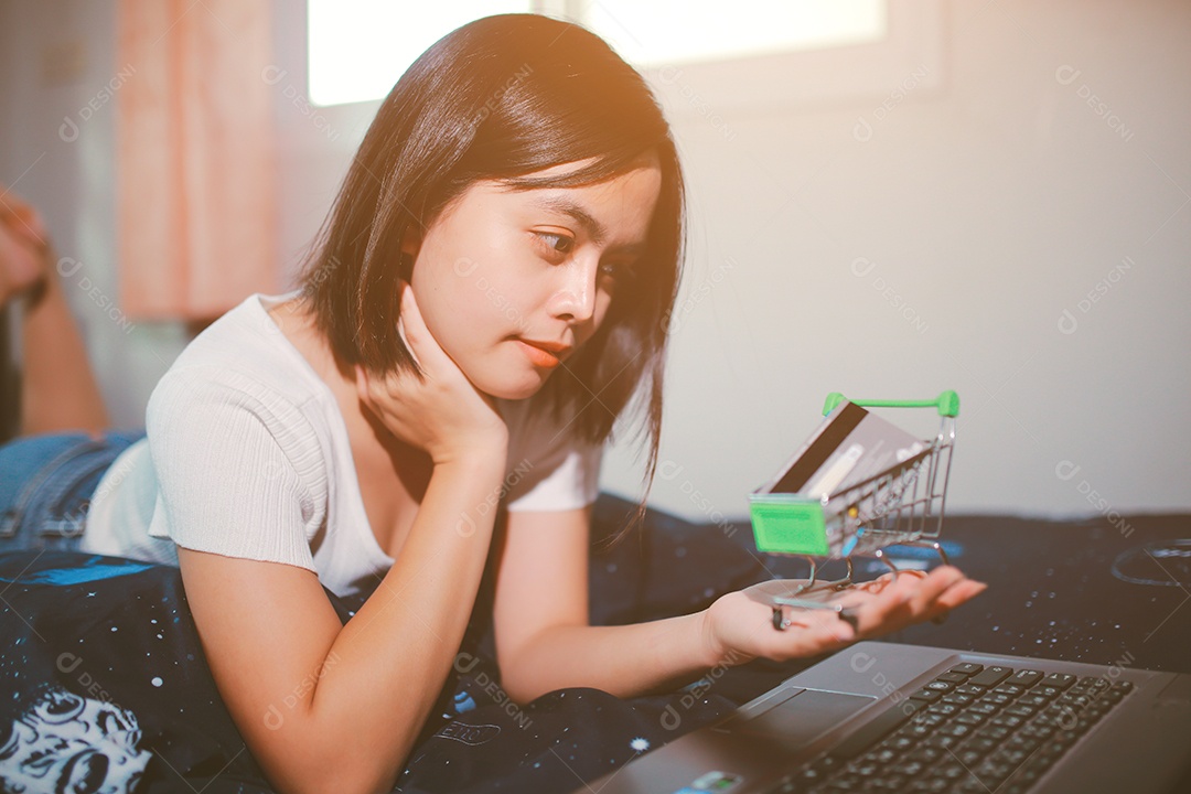 Jovem relaxando e usando o laptop fazendo compras online