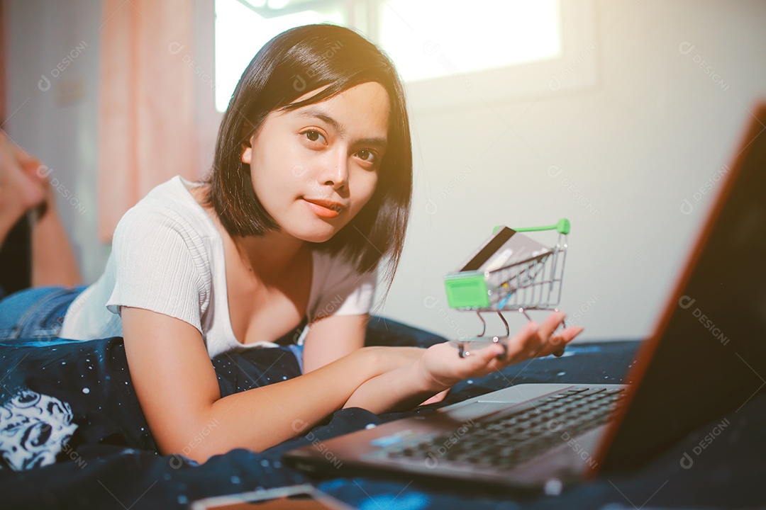 Jovem relaxando e usando o laptop fazendo compras online