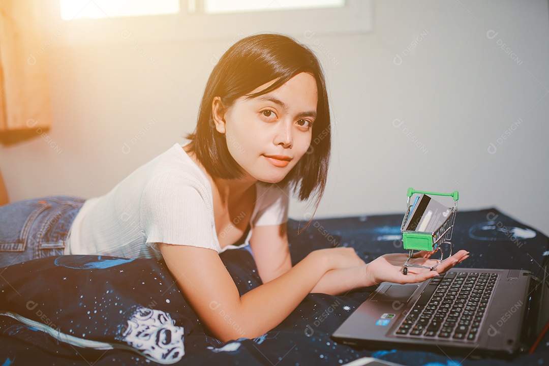 Jovem relaxando e usando o laptop fazendo compras online