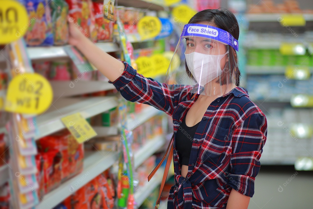 Mulher asiática em protetor facial, máscara médica fazendo compras