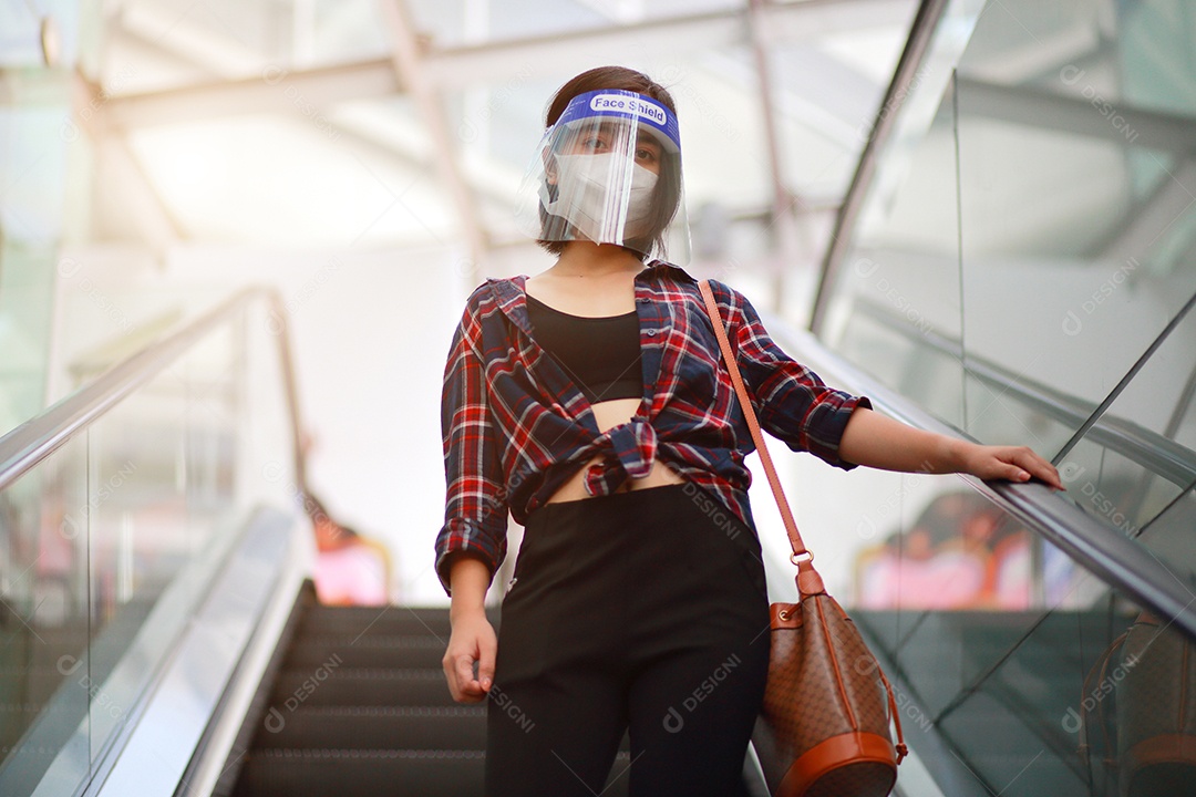 Mulher asiática em escudo facial, máscara facial médica desce a escalada