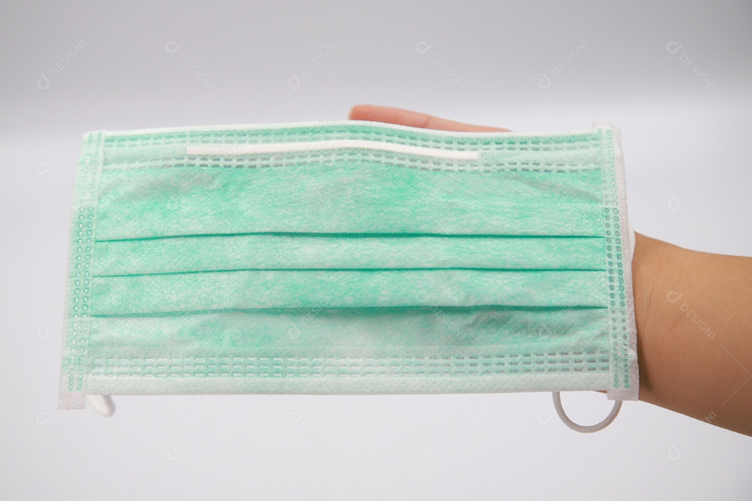 Mulher segurando máscara antiviral protetora cirúrgica sobre texto verde