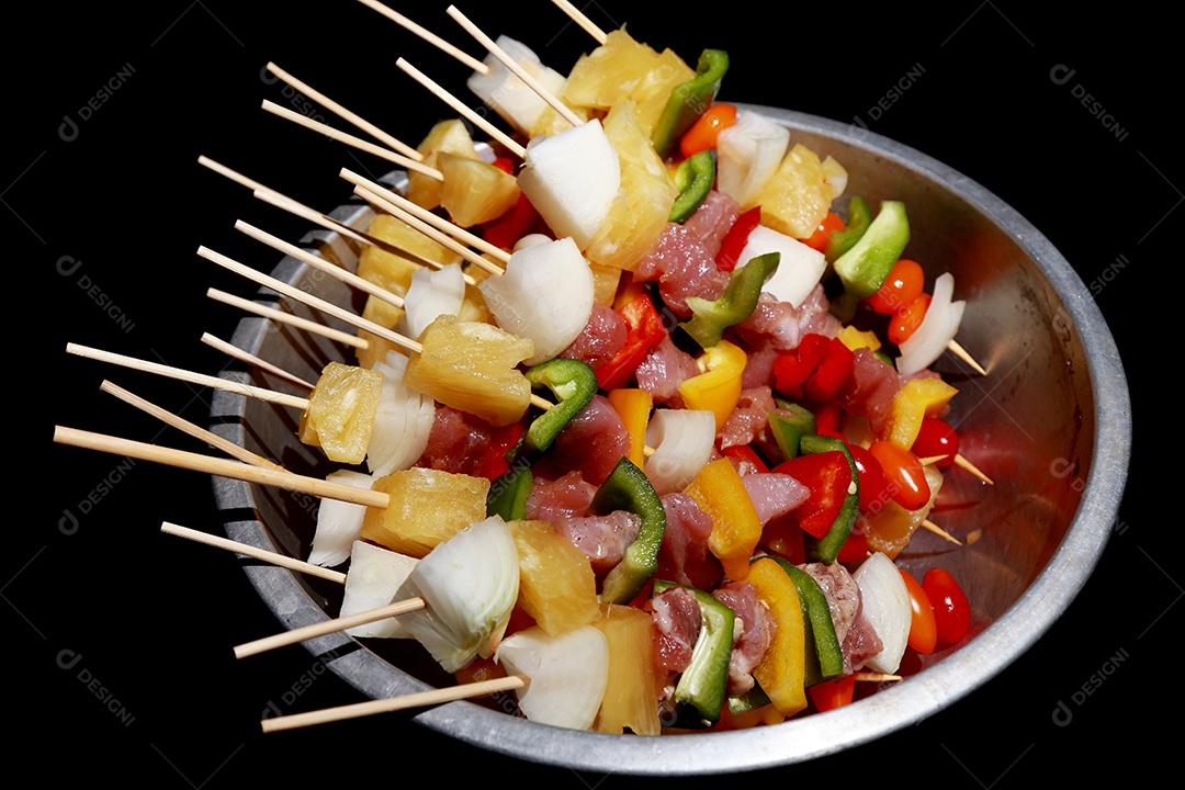 Kebab cru de carne em um fundo de madeira com legumes.