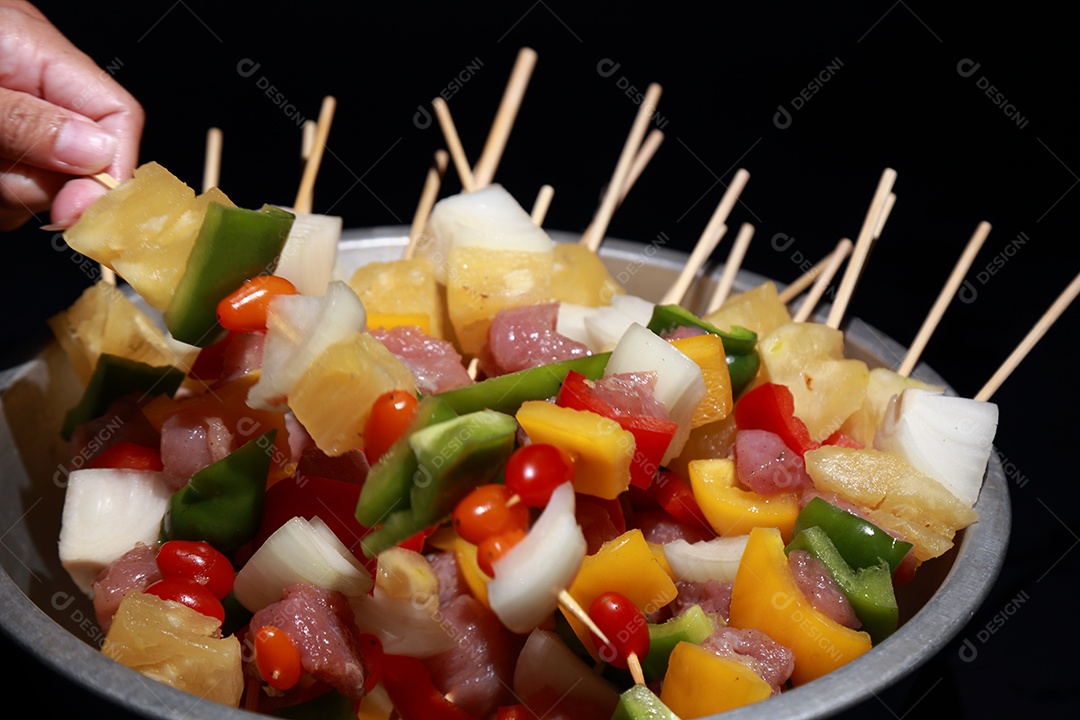 Kebab cru de carne em um fundo de madeira com legumes.