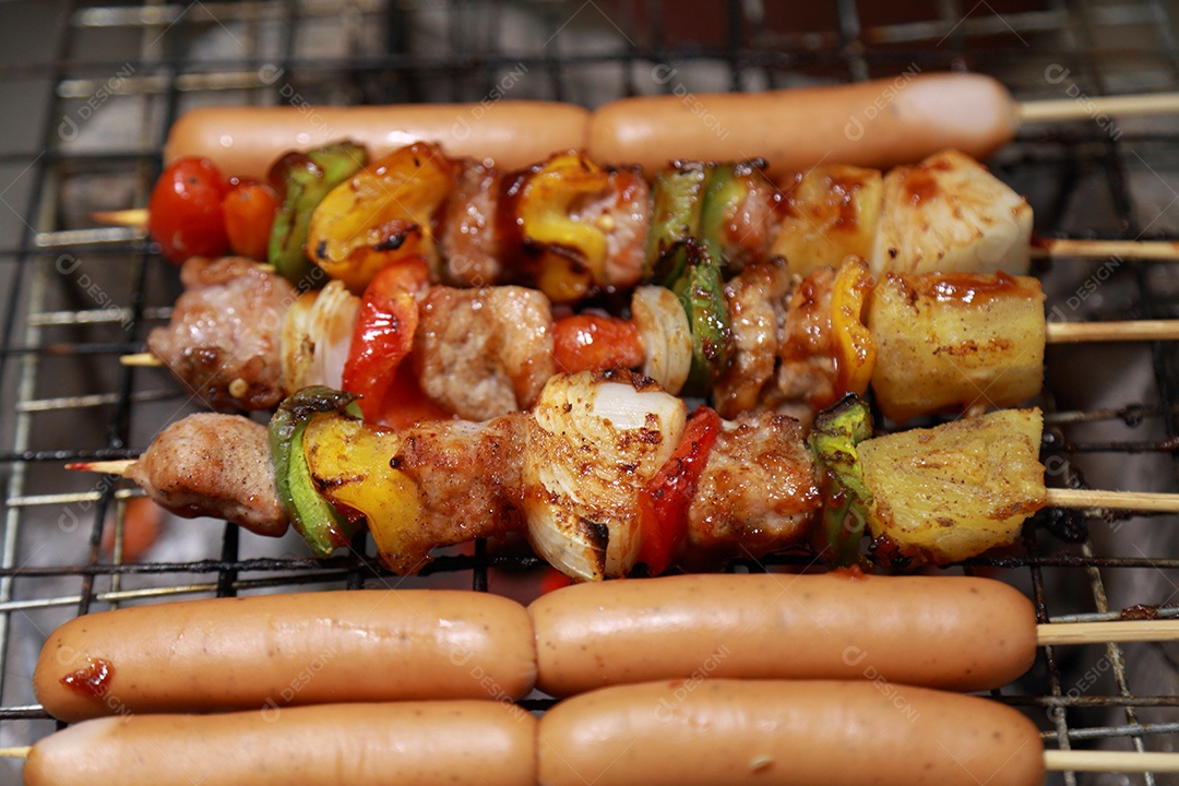 Fechar-se sortidas deliciosas carnes grelhadas com legumes sobre as brasas em um churrasco