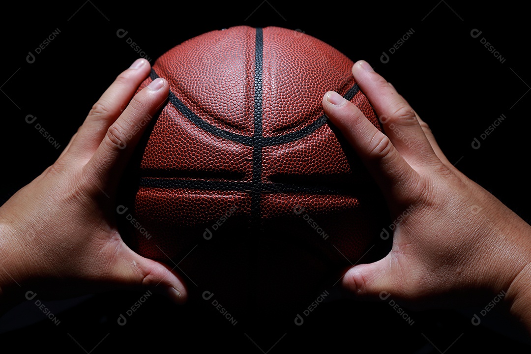 Mãos segurando bolas de basquete no fundo cinza do estúdio. conceito de confronto.