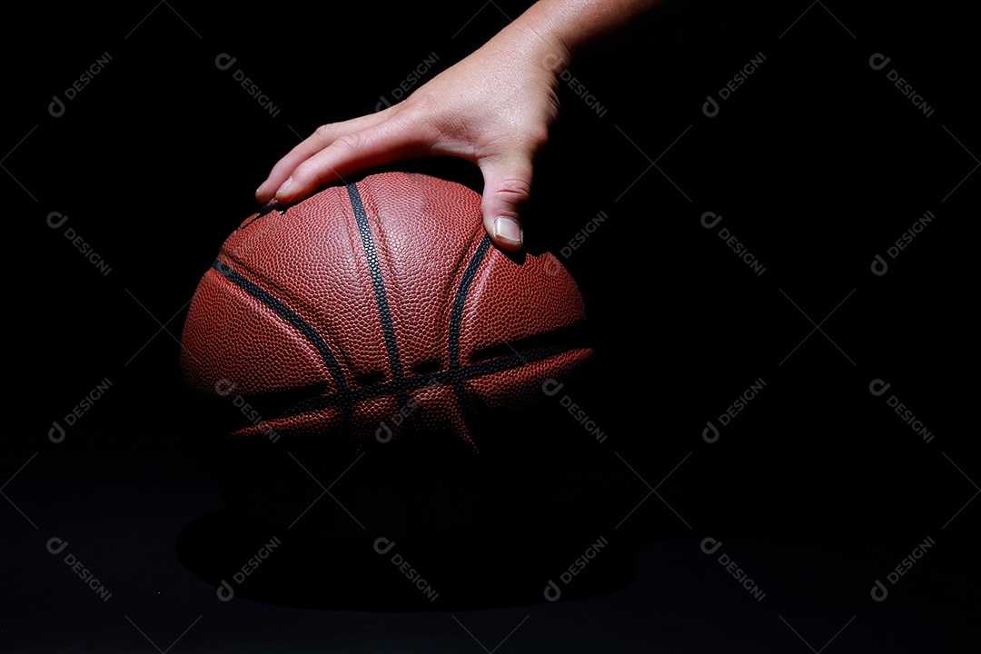 Mãos segurando bolas de basquete no fundo cinza do estúdio. conceito de confronto.