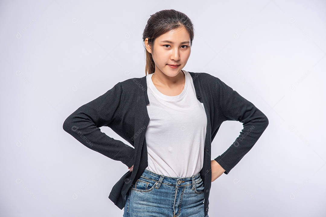 Uma mulher de camisa preta está de pé e segurando uma alça no cabelo